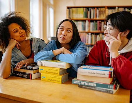 Three women leaning on books